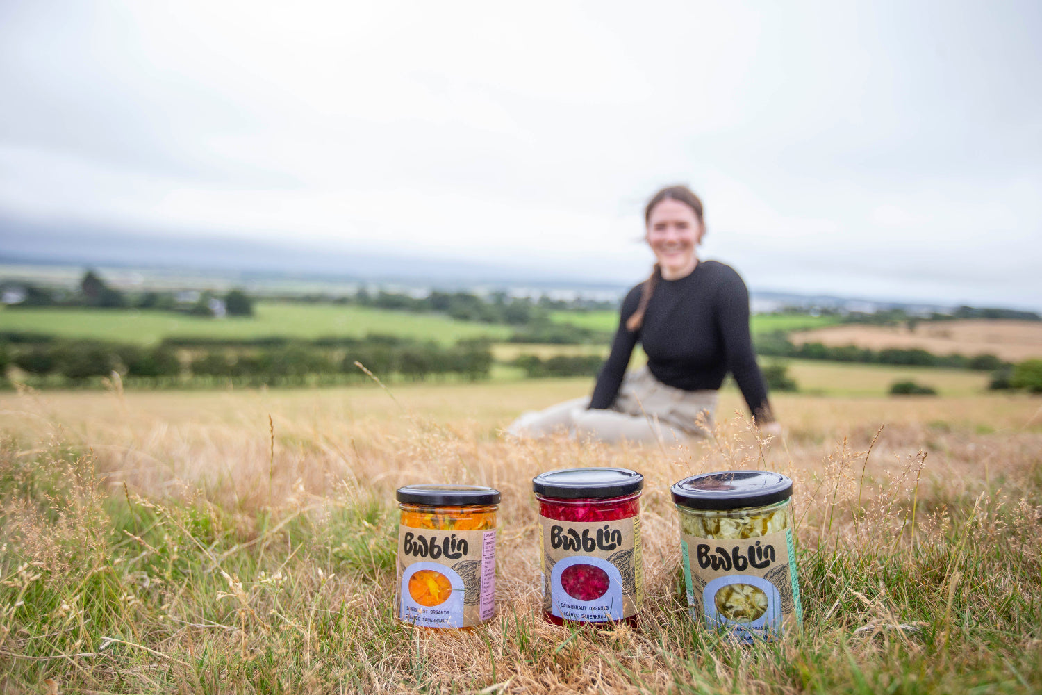 Person sitting in a field with Boblin canisters in the foreground