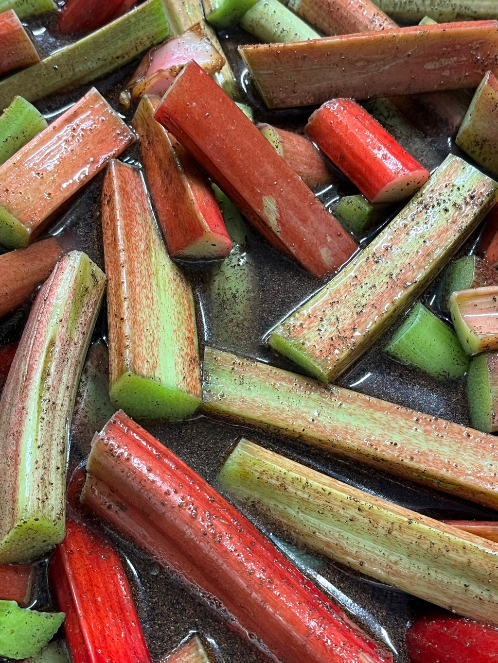 Close-up of sliced rhubarb pieces on a dark surface