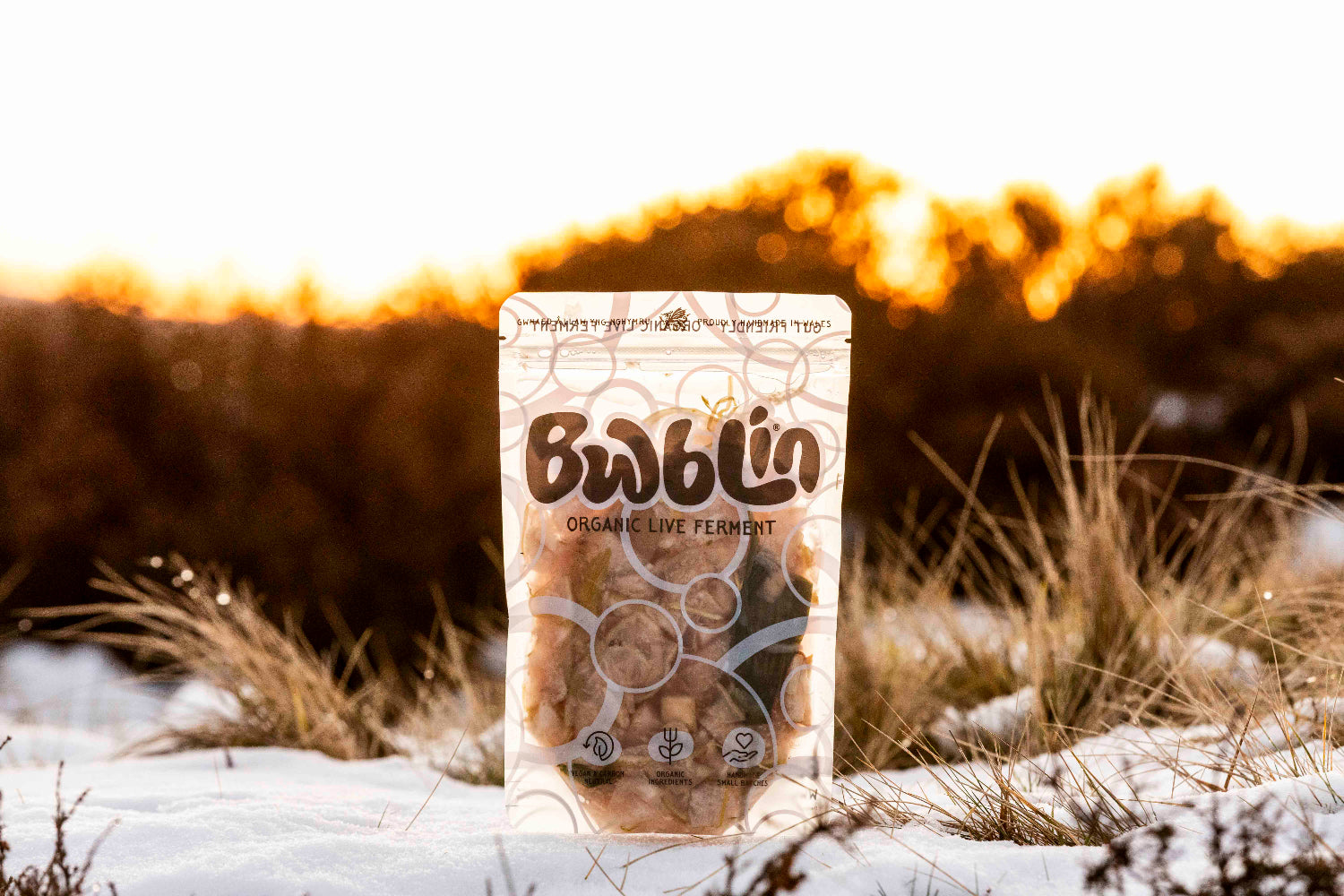 Bag of Bwblin organic live ferment on a snowy ground with a blurred natural background