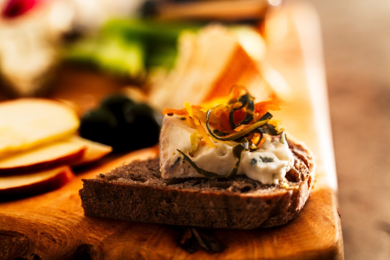 Toast with sauerkraut and cream cheese and herbs on a wooden board