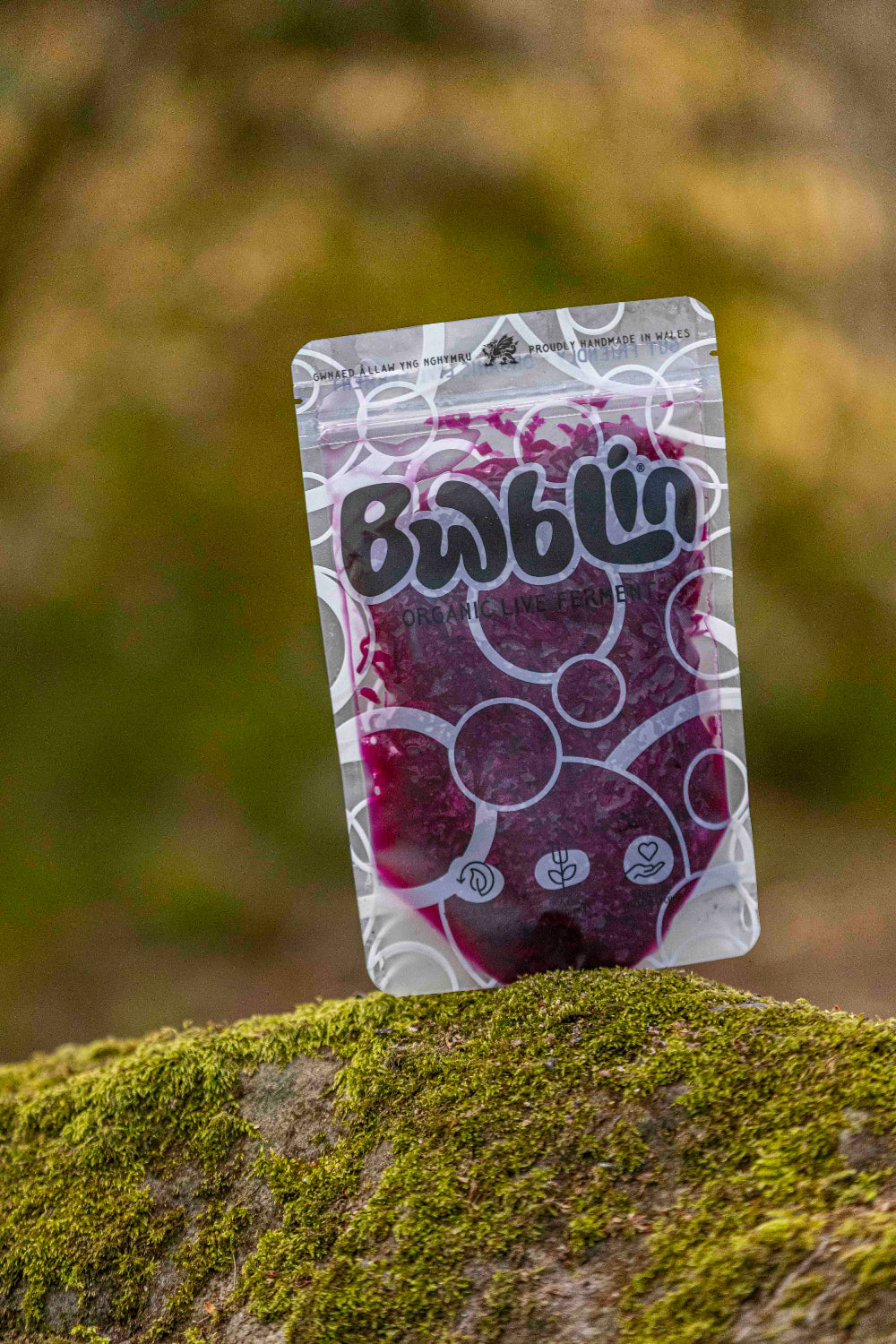 Packaged snack on a mossy surface with a blurred natural background