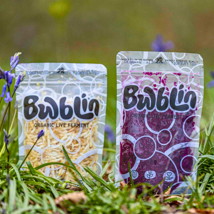 Two packages of Bublin in a grassy area with flowers