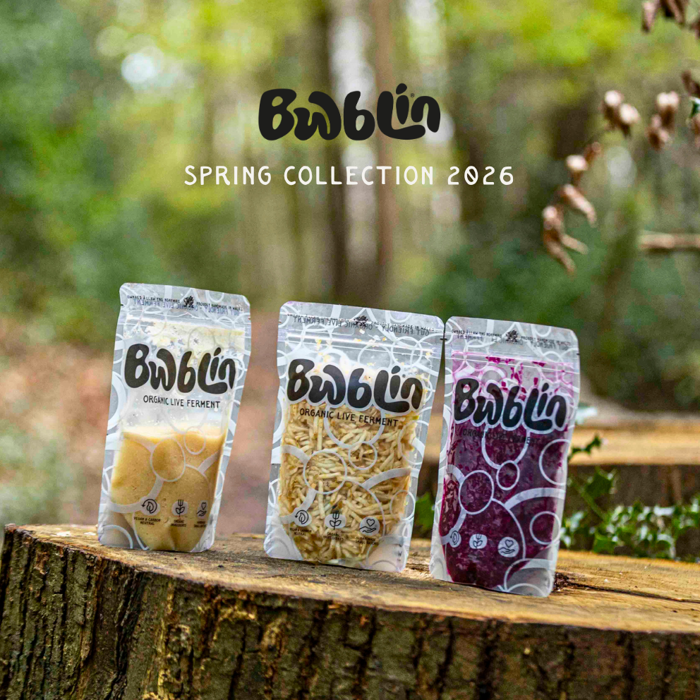 Three packages of 'Bwblin' snacks on a wooden log with a natural background